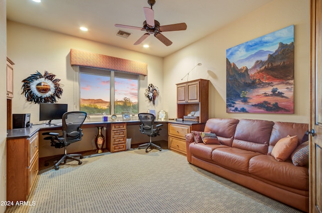 office area featuring light colored carpet, built in desk, and ceiling fan