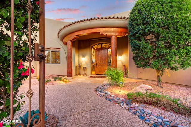 exterior entry at dusk with a patio