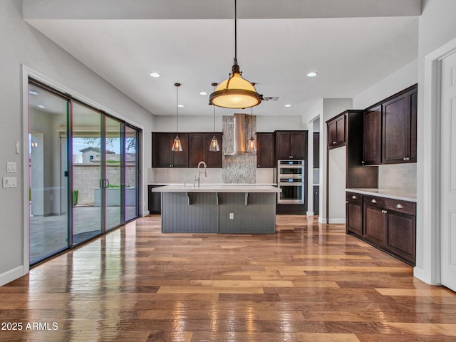 3809 E Lynx Pl, Chandler, AZ 85249 - kitchen featuring stainless steel double oven, hardwood / wood-style flooring, backsplash, light countertops, and dark brown cabinets