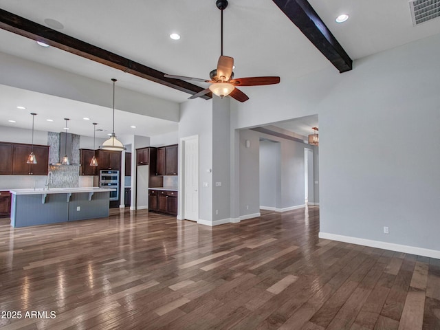 3809 E Lynx Pl, Chandler, AZ 85249 - unfurnished living room featuring beam ceiling, dark wood finished floors, baseboards, ceiling fan, and recessed lighting