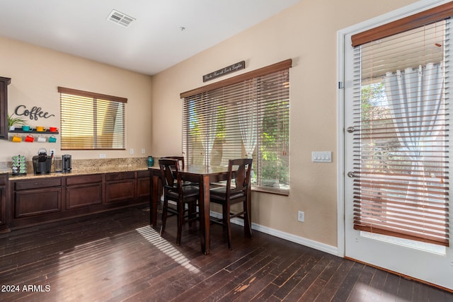 dining room featuring dark wood-type flooring and a wealth of natural light