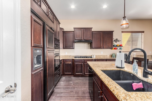 kitchen with sink, decorative light fixtures, stainless steel gas stovetop, light stone counters, and dark hardwood / wood-style floors