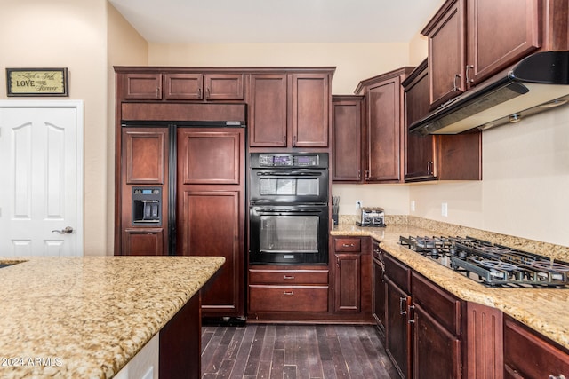 kitchen with dark wood-type flooring, stainless steel gas cooktop, double oven, light stone counters, and paneled refrigerator