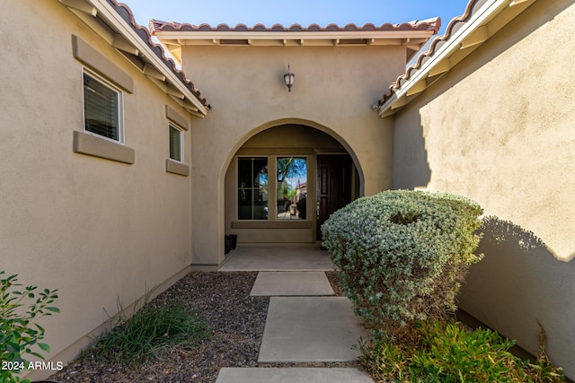 view of exterior entry with a patio area