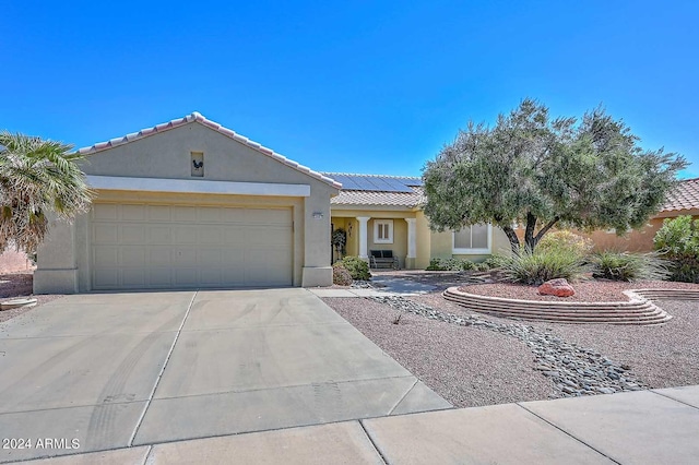 view of front of home with solar panels and a garage