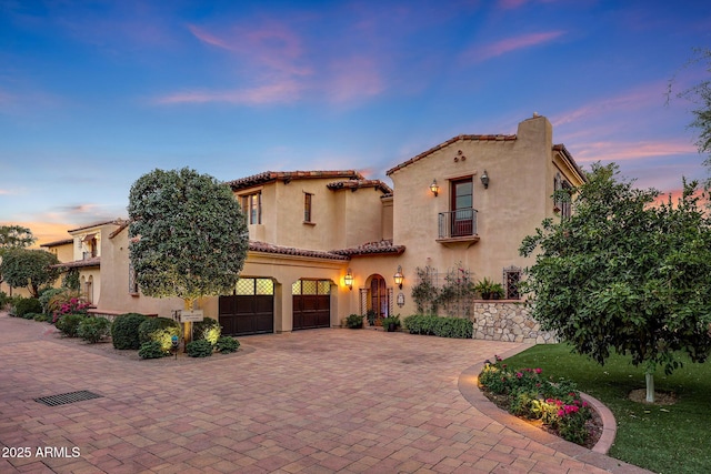 mediterranean / spanish-style home with a balcony and a garage