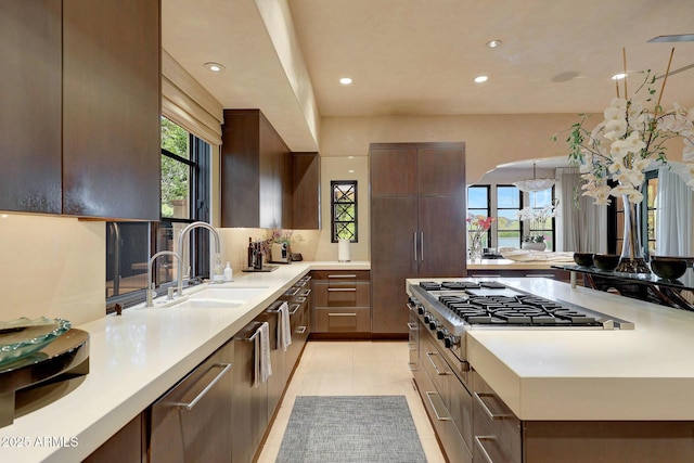 kitchen with stainless steel gas stovetop, light tile patterned floors, and sink