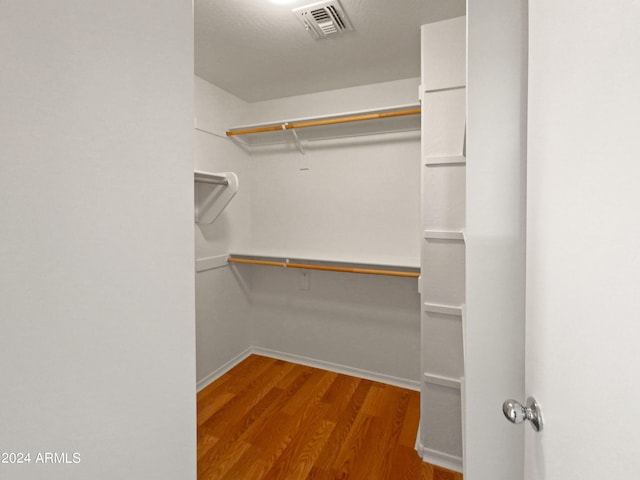 walk in closet with hardwood / wood-style floors