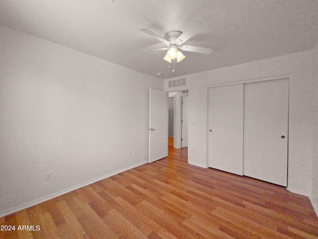 unfurnished bedroom featuring ceiling fan, light wood-type flooring, and a closet