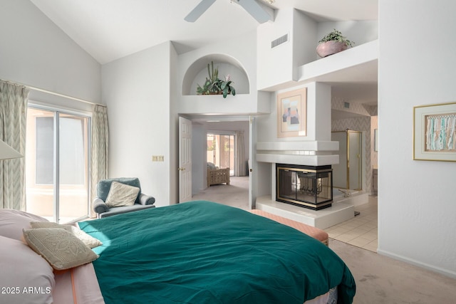 bedroom featuring a multi sided fireplace, high vaulted ceiling, ceiling fan, and light colored carpet