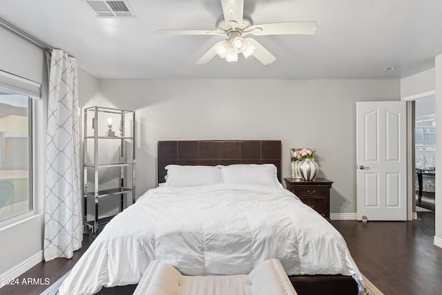 bedroom with dark hardwood / wood-style flooring and ceiling fan