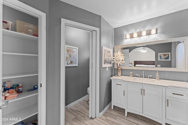 bathroom featuring hardwood / wood-style flooring, vanity, toilet, and built in shelves