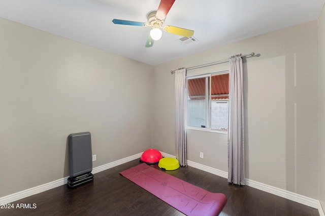 exercise area featuring ceiling fan and dark wood-type flooring