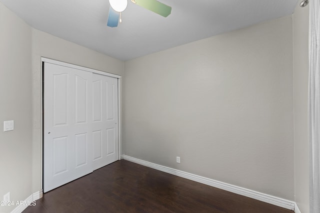 unfurnished bedroom featuring ceiling fan, dark hardwood / wood-style flooring, and a closet