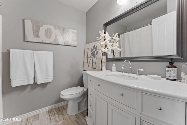 bathroom featuring vanity, hardwood / wood-style flooring, and toilet