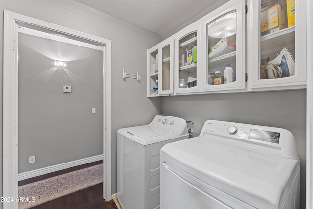 clothes washing area featuring dark hardwood / wood-style floors, cabinets, independent washer and dryer, and a textured ceiling