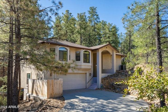 view of front of property with a garage and central air condition unit