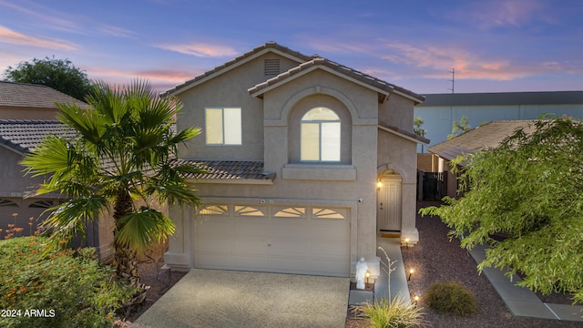 3211 E Kerry Ln, Phoenix, AZ 85050 - view of front of house featuring a tiled roof, driveway, stucco siding, and an attached garage