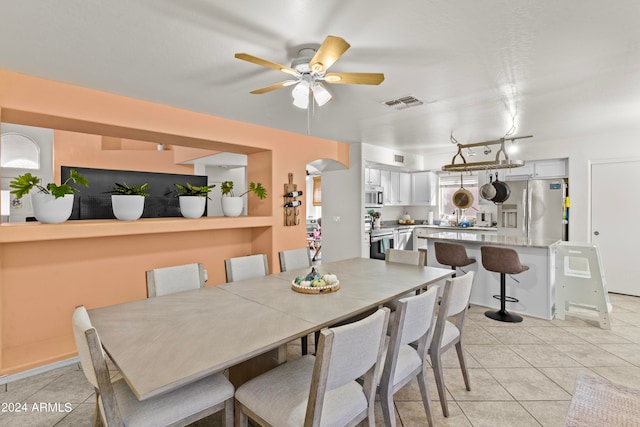 tiled dining space featuring ceiling fan