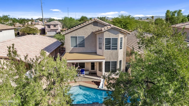3211 E Kerry Ln, Phoenix, AZ 85050 - rear view of property with stucco siding, an outdoor pool, a tiled roof, and a patio