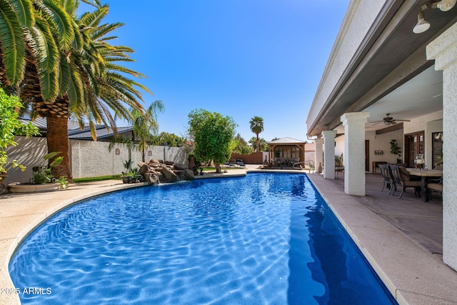 view of pool featuring a gazebo, a fenced backyard, a patio, ceiling fan, and outdoor dining area