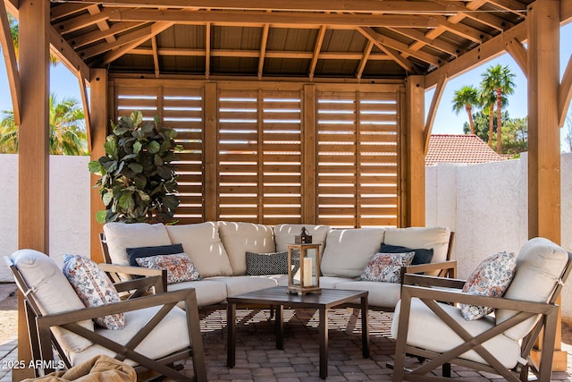 view of patio featuring outdoor lounge area, fence, and a gazebo
