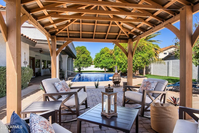view of patio / terrace with a gazebo, ceiling fan, an outdoor hangout area, and fence
