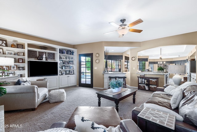 carpeted living area featuring a ceiling fan and baseboards