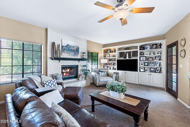 living area with carpet flooring, a brick fireplace, ceiling fan, and baseboards