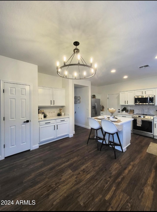 kitchen with a center island, white cabinets, hanging light fixtures, dark hardwood / wood-style floors, and stainless steel appliances