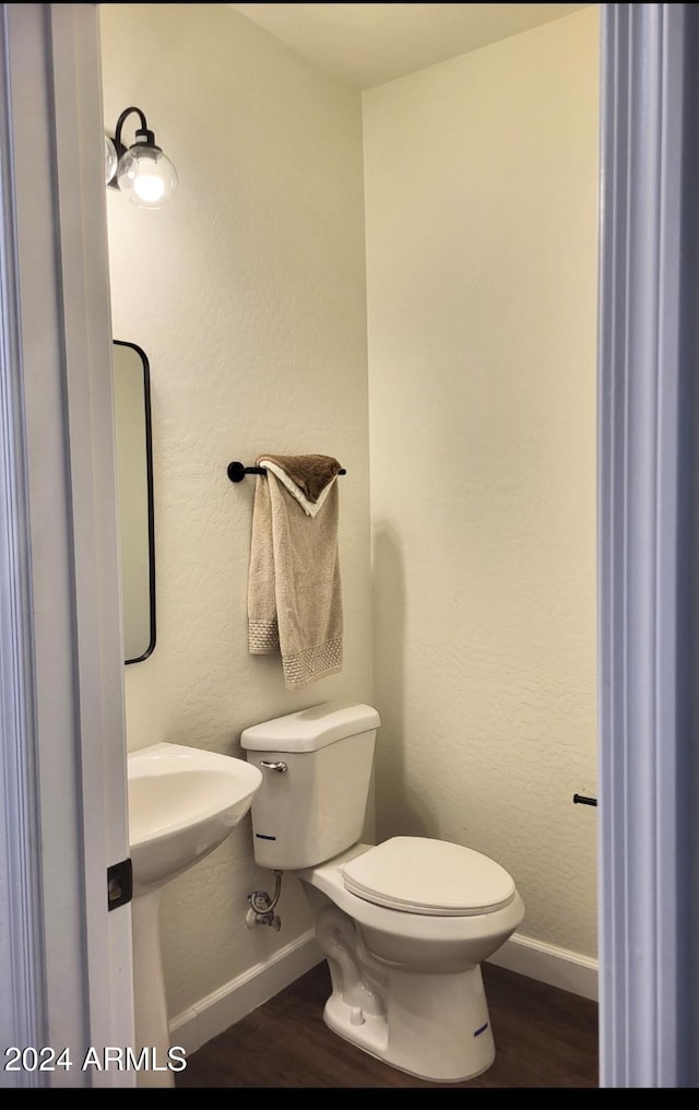 bathroom with hardwood / wood-style floors and toilet