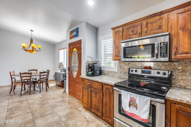 kitchen with tasteful backsplash, hanging light fixtures, stainless steel appliances, light stone counters, and a chandelier