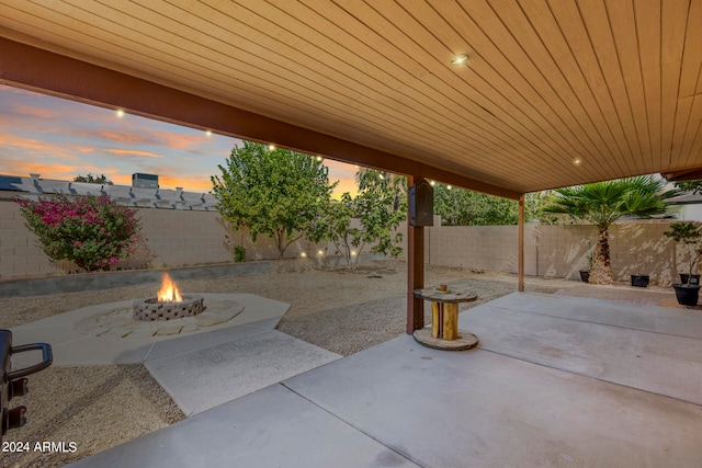 patio terrace at dusk featuring an outdoor fire pit