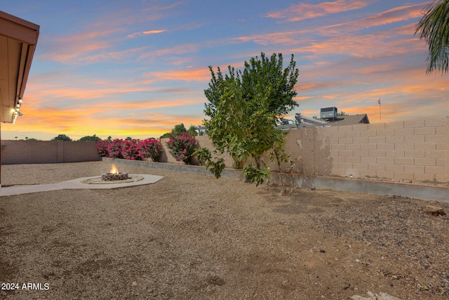 yard at dusk featuring a fire pit