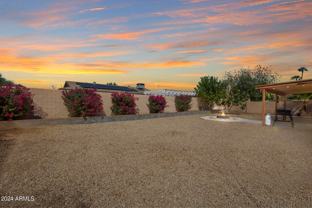 yard at dusk with an outdoor fire pit and a patio area