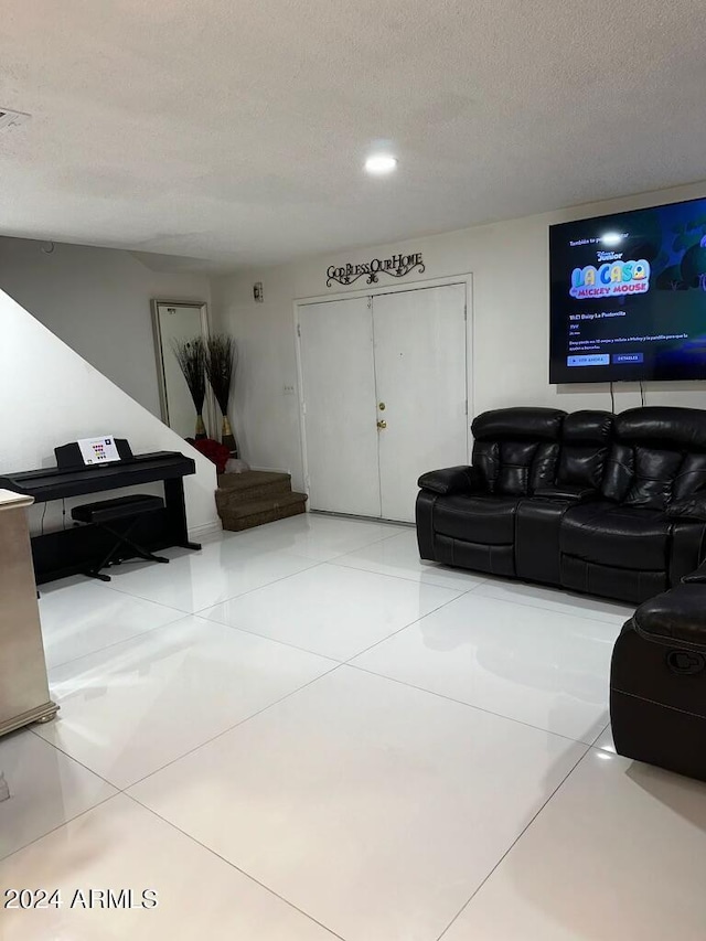 living room featuring light tile patterned flooring and a textured ceiling