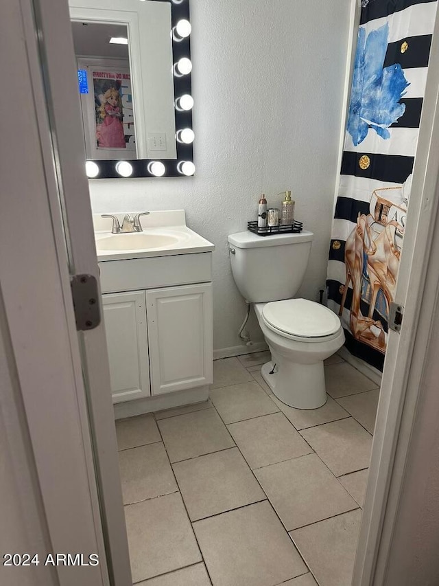 bathroom with tile patterned flooring, vanity, and toilet