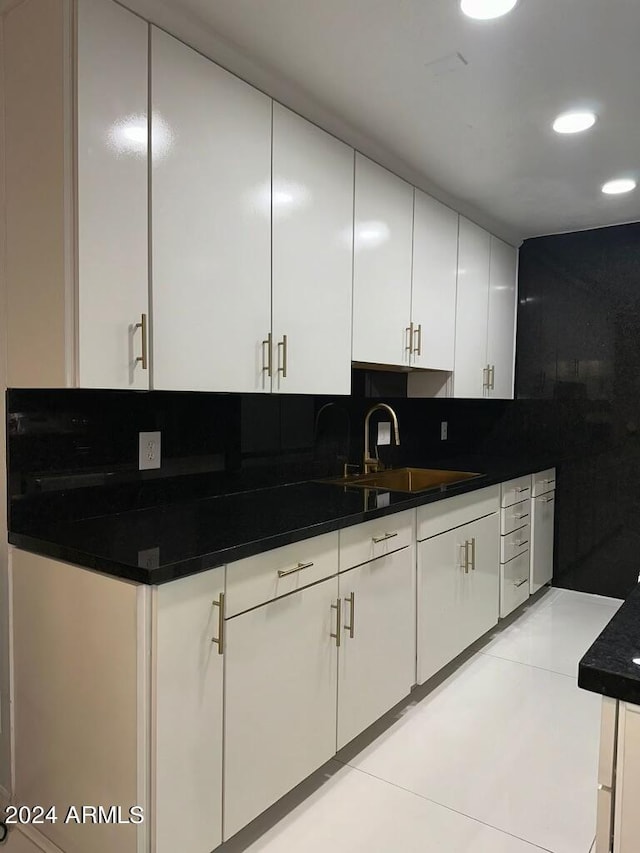 kitchen with white cabinetry, sink, light tile patterned floors, and tasteful backsplash