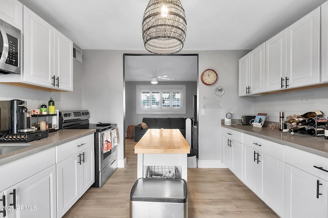 kitchen featuring stainless steel appliances, white cabinets, and light wood-type flooring