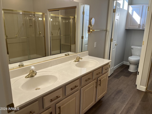 bathroom featuring toilet, a shower with door, vanity, and hardwood / wood-style flooring