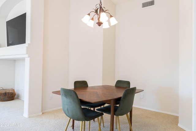 dining space featuring light carpet and a notable chandelier