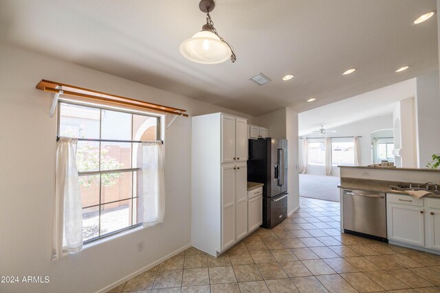 kitchen with stainless steel appliances, vaulted ceiling, hanging light fixtures, and white cabinets