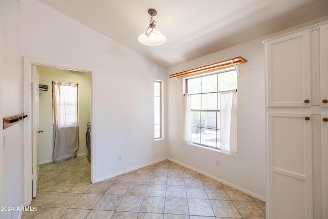 unfurnished room featuring light tile patterned flooring and lofted ceiling