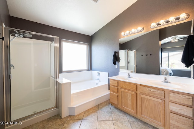 bathroom with independent shower and bath, vanity, lofted ceiling, and tile patterned floors