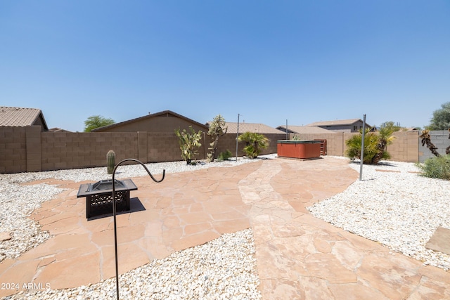 view of patio with a hot tub and an outdoor fire pit