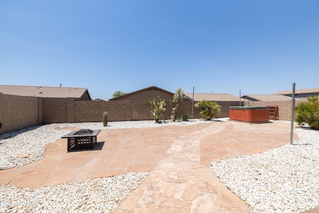 view of patio featuring an outdoor fire pit and a hot tub