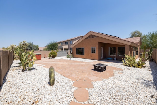 rear view of house featuring a patio and a fire pit