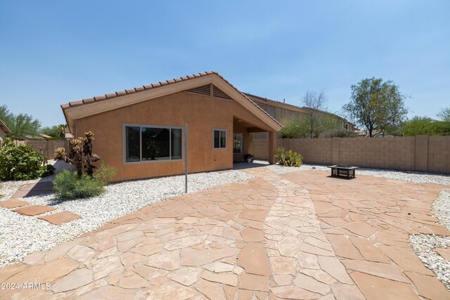 view of patio / terrace featuring a hot tub and an outdoor fire pit