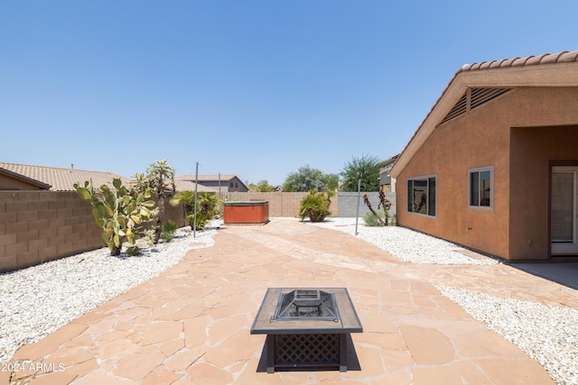 view of patio with a hot tub and an outdoor fire pit