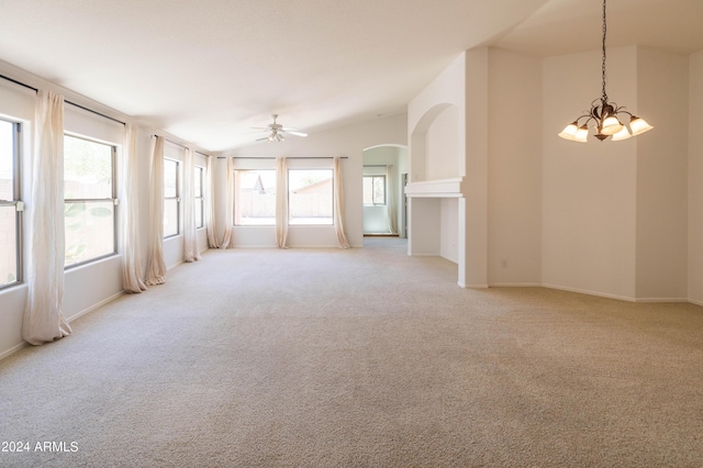 carpeted empty room featuring lofted ceiling and ceiling fan with notable chandelier